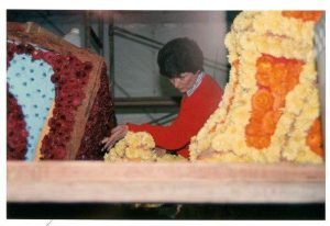 A woman puts the finishing touches on the 1990 float “Sound Waves.”