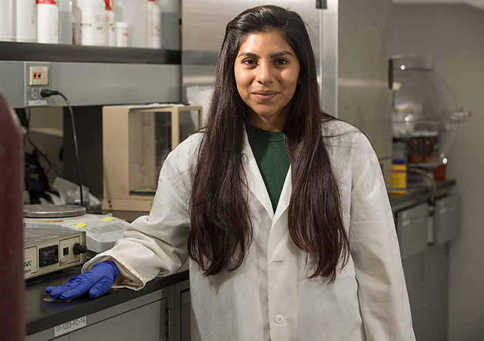 Cinthia Ayala wearing a lab coat inside a lab room