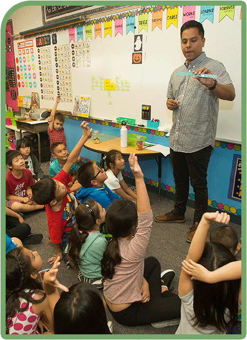 An alumnus teaching elementary school kids in the classroom