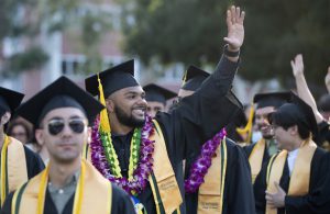 A graduate waving during Commencement